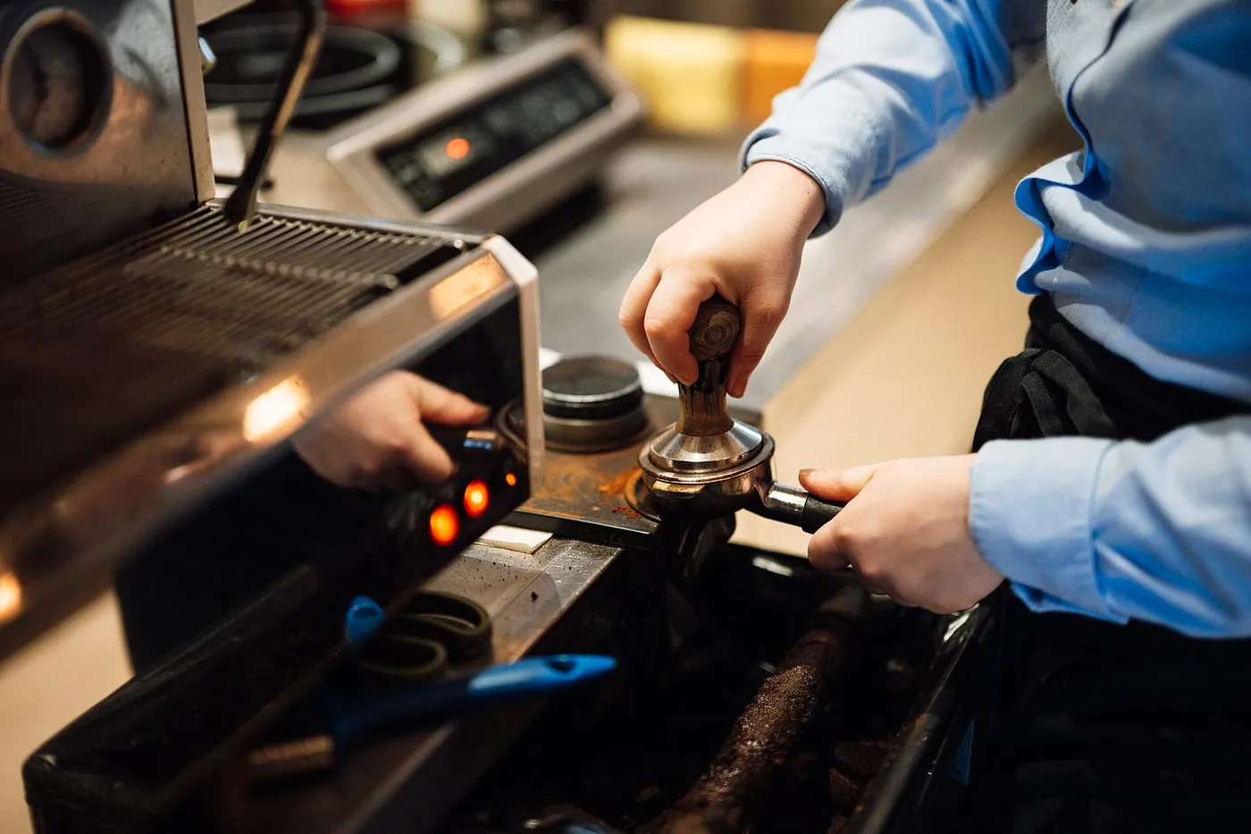 Espresso being pulled into two cups, close, steam, a Thai barista's hands.