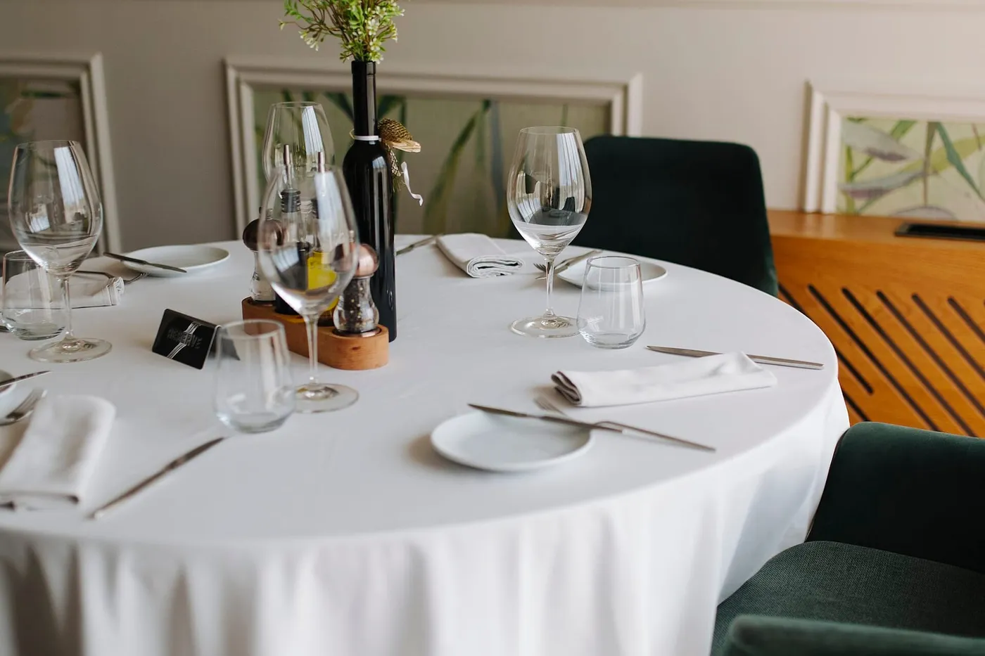 A shared table set for dinner, several plates, chairs pulled out, evening.